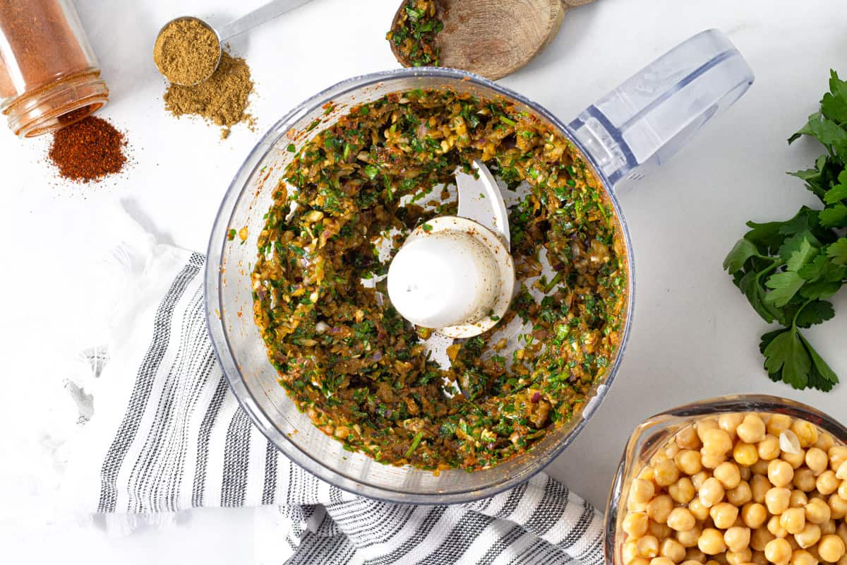 Food processor filled with ingredients to make falafel