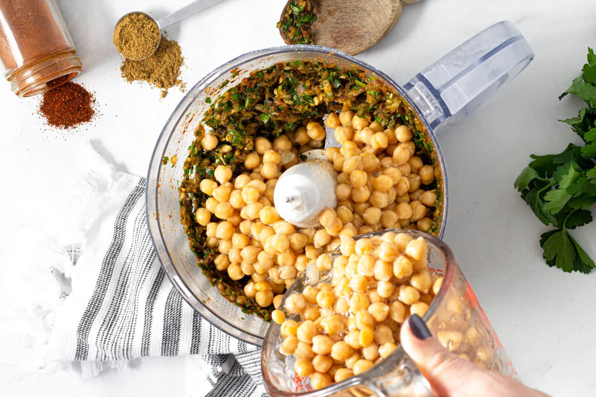 Food processor filled with ingredients to make falafel