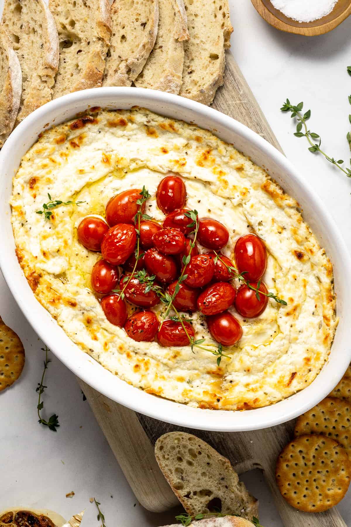 Overshot shot of baked goat cheese dip garnished with fresh thyme
