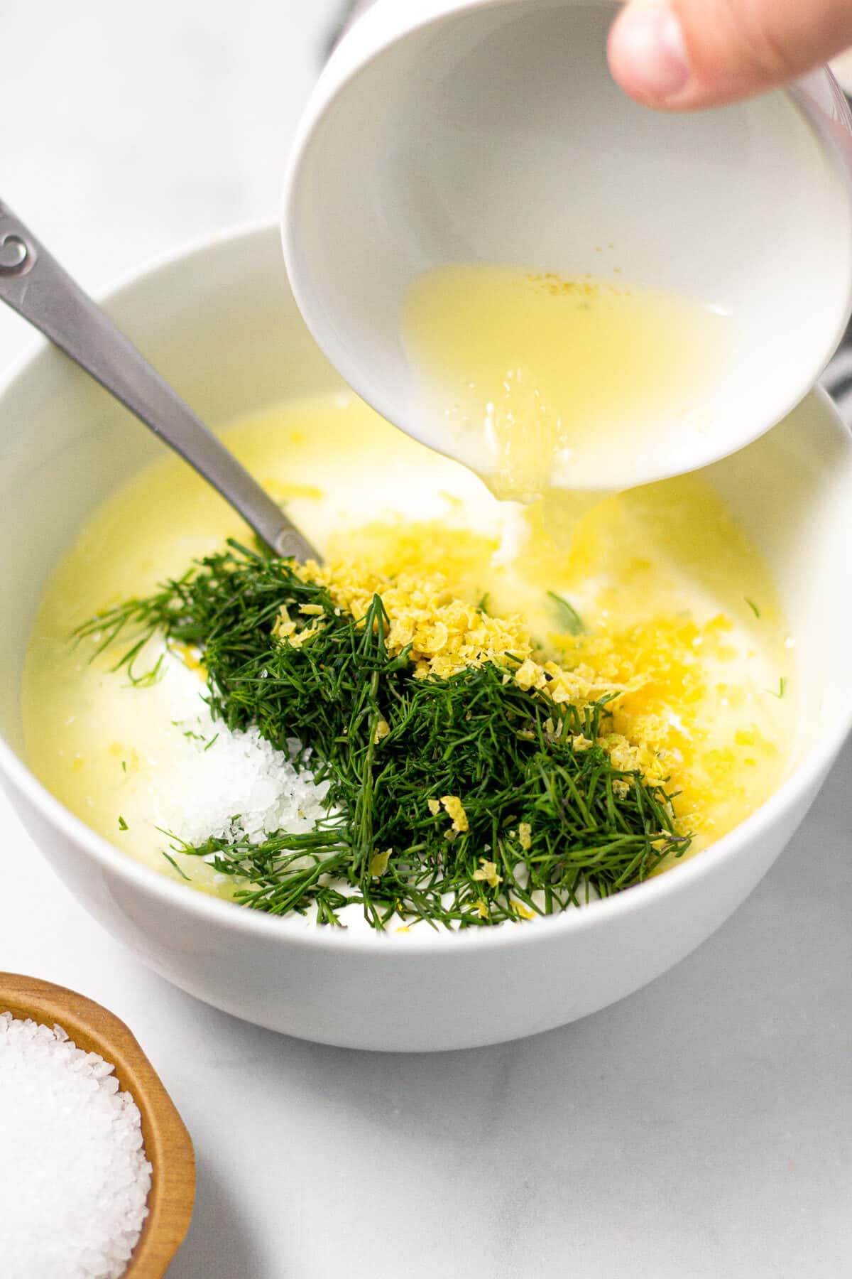 White bowl filled with ingredients to make Greek yogurt sauce