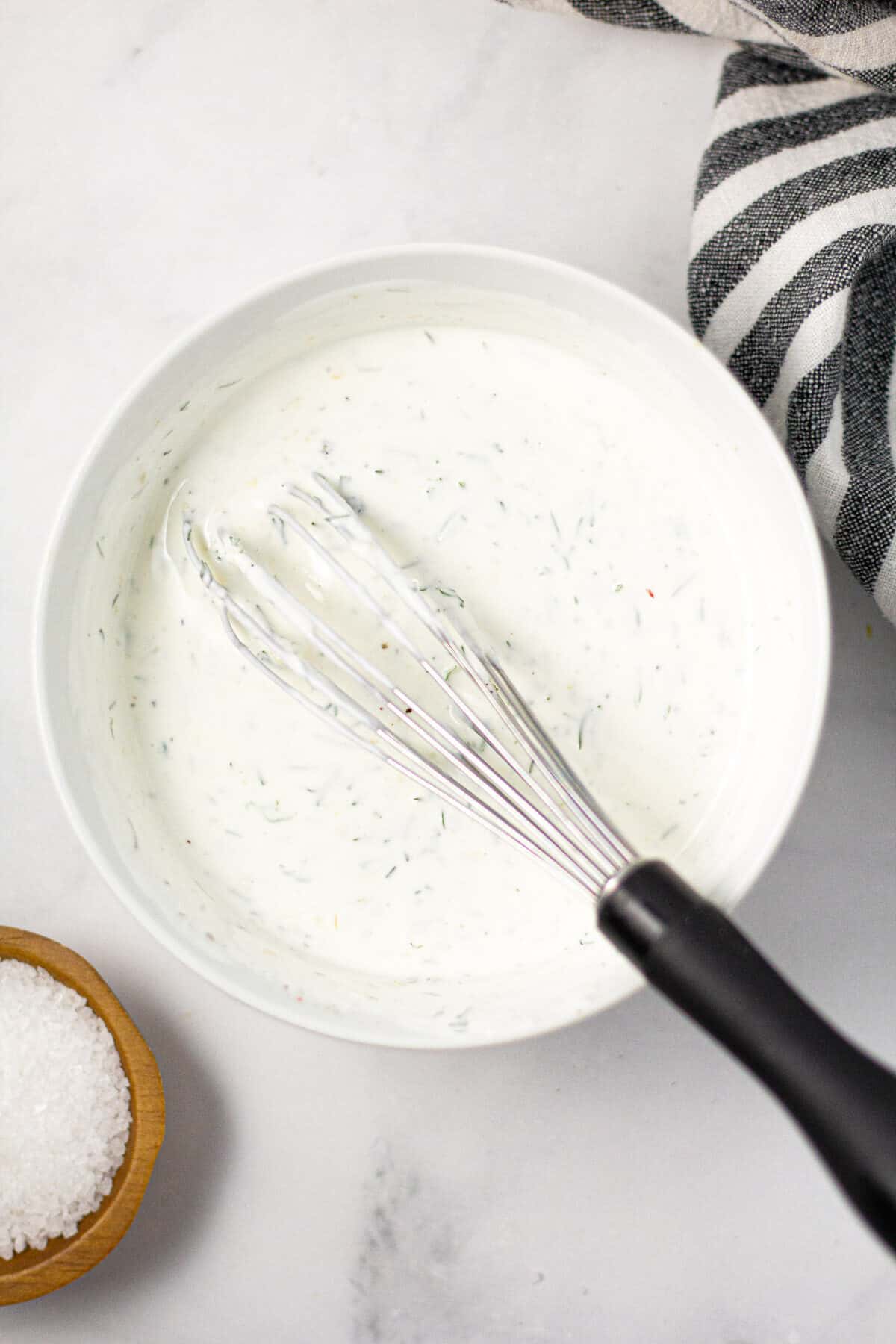 White bowl filled with homemade Greek yogurt sauce whisked together