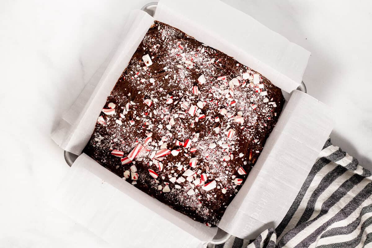 Square metal pan filled with peppermint brownies ready to go in the oven 
