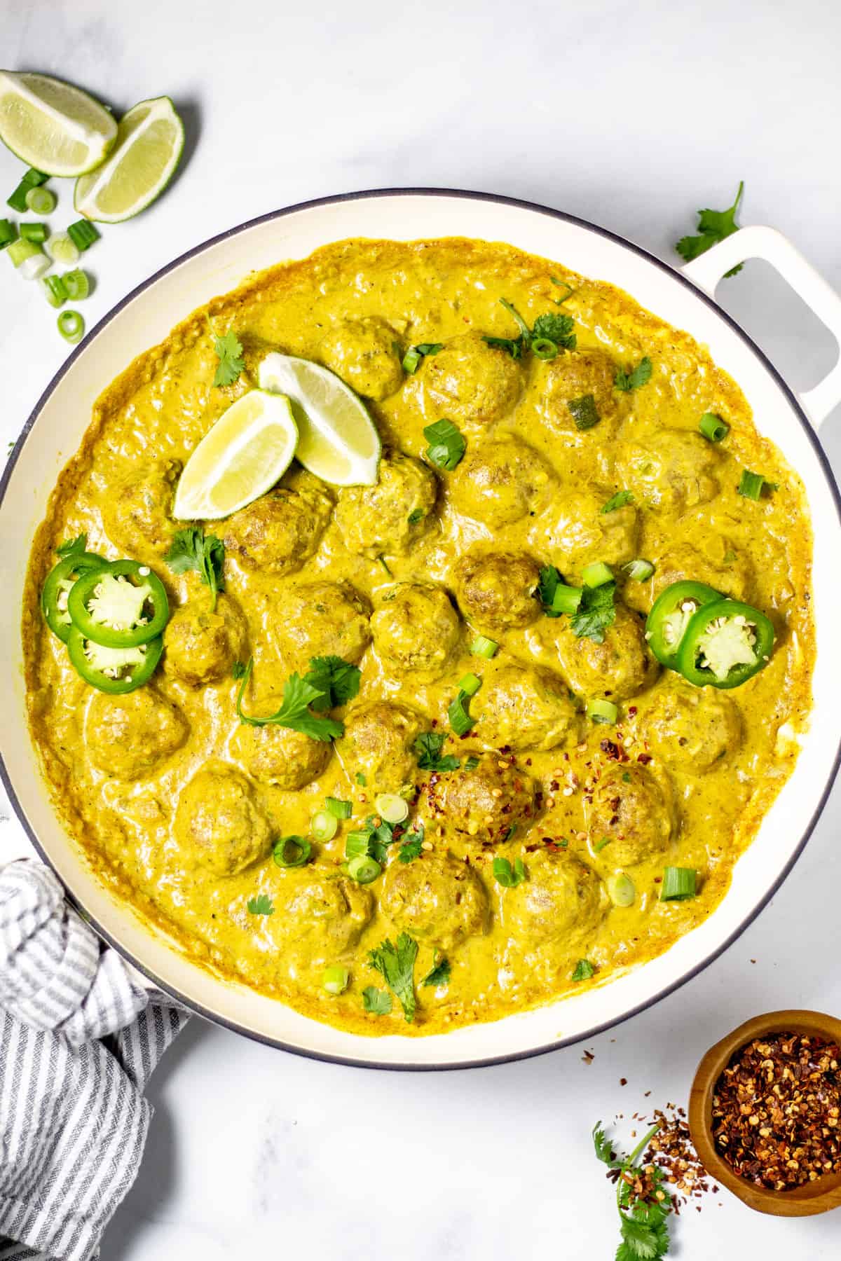 Overhead shot of a pan of curried pork meatballs garnished with fresh cilantro
