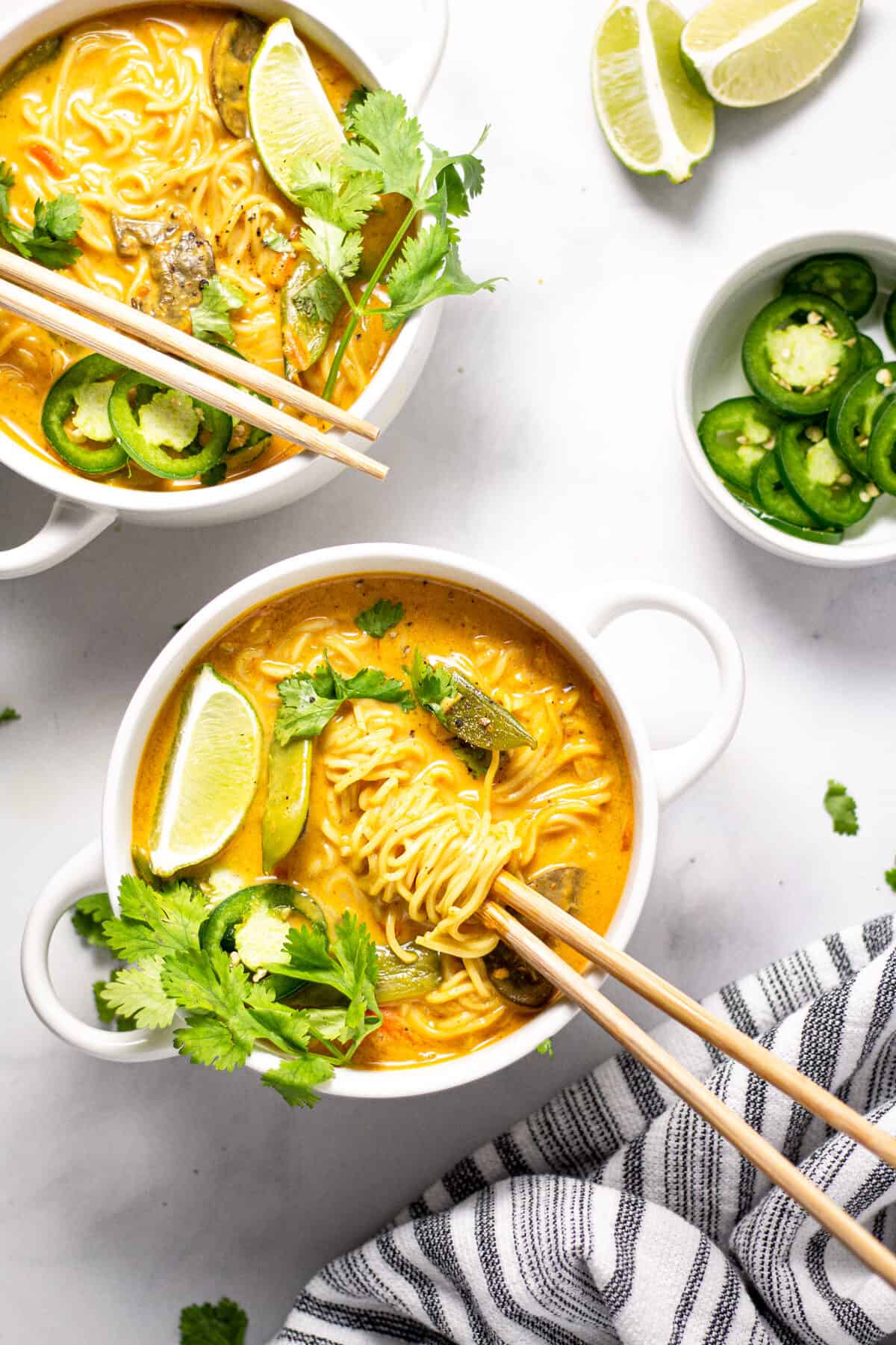 Overhead shot of two bowls of curry ramen noodle soup garnished with fresh cilantro 