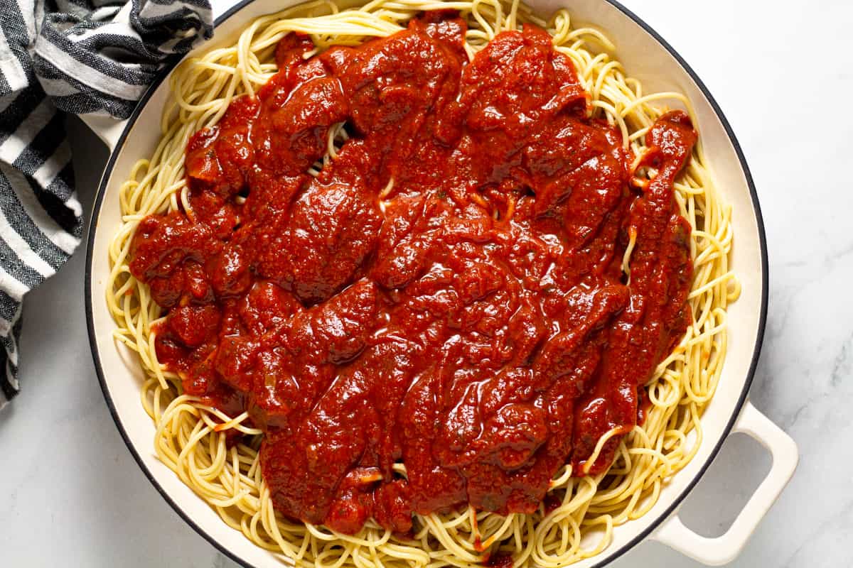 Large white pan filled with spaghetti and red pasta sauce