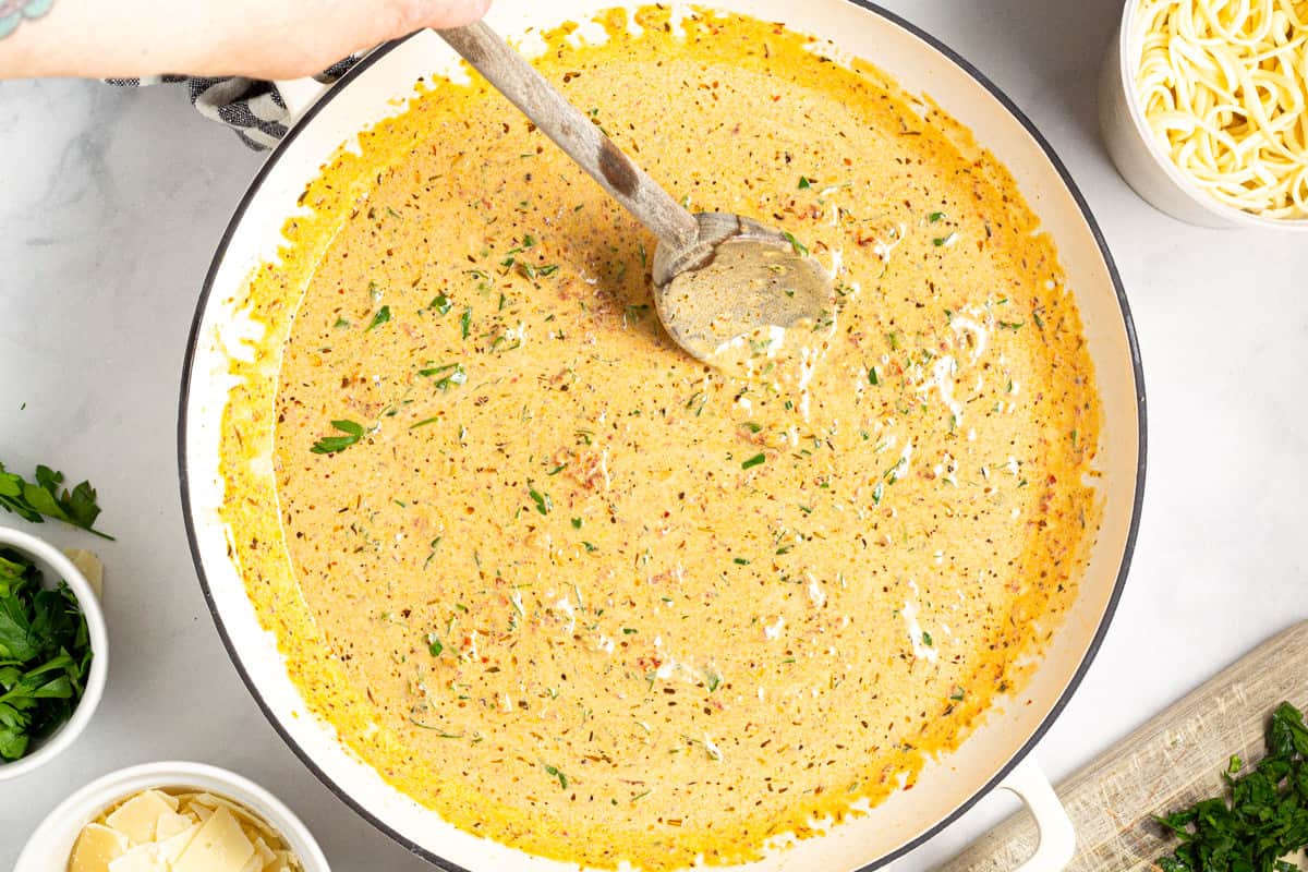 A pan filled with creamy sun dried tomato sauce 