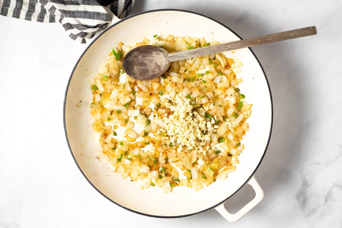 Overhead shot of a white pan filled with sauteed onion jalapeno and garlic
