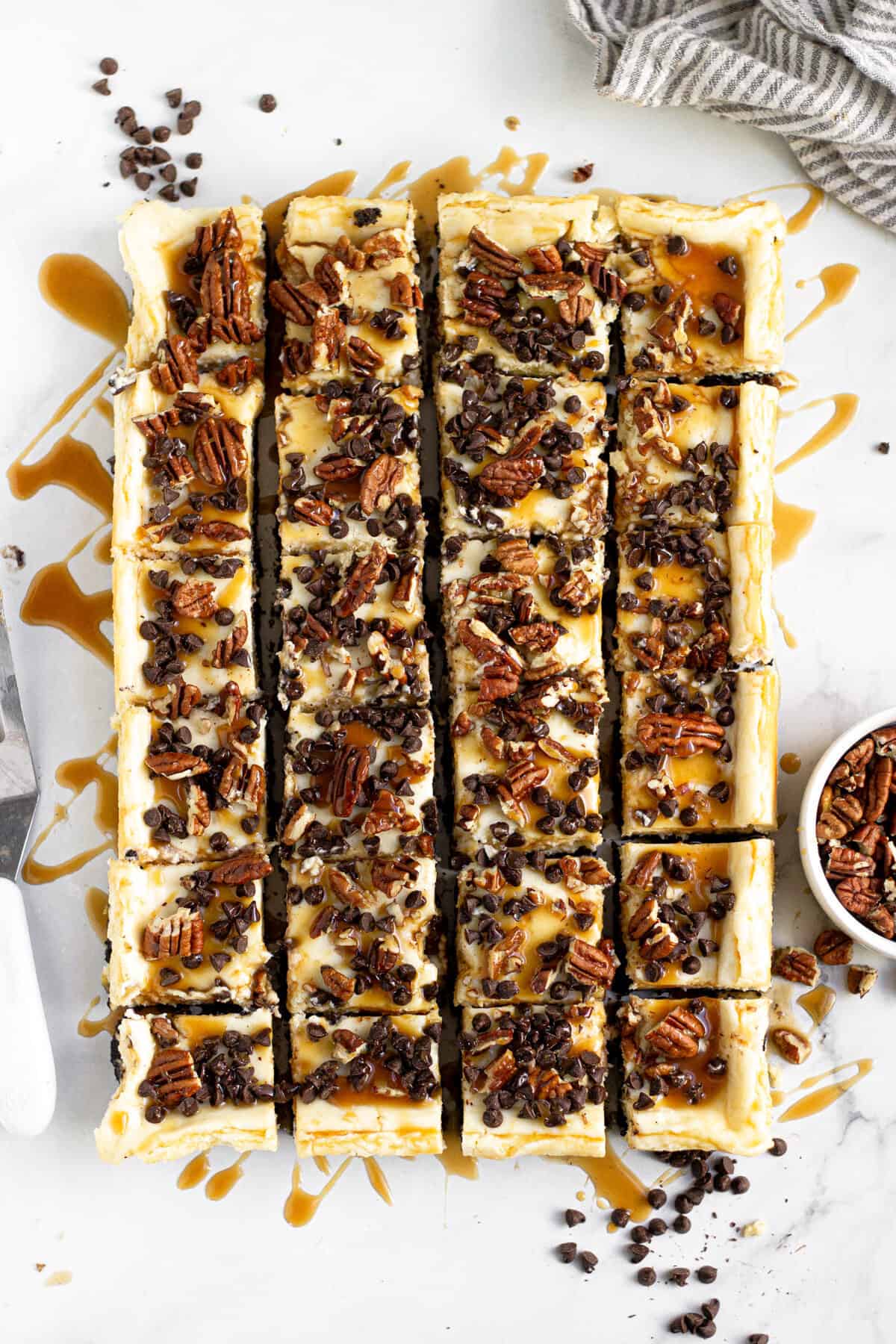 Overhead shot of turtle cheesecake bars cut into squares 