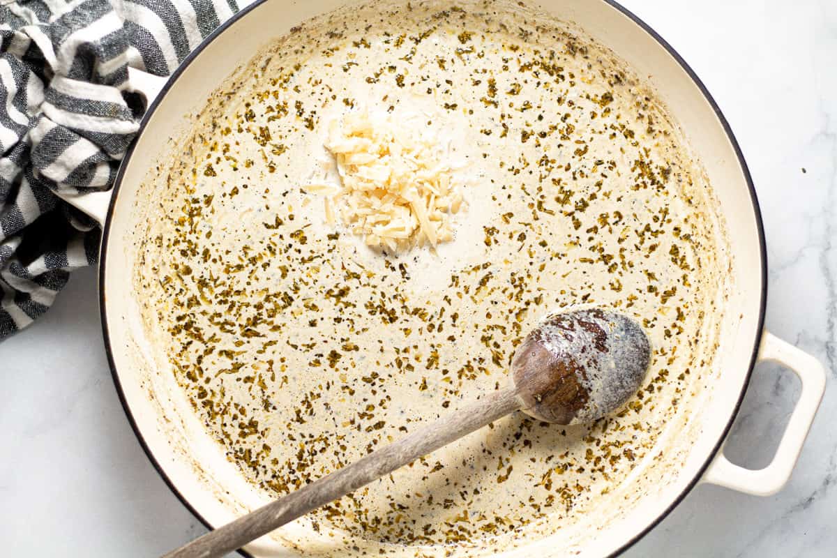 Large white pan with half and half dried herbs and Parmesan cheese
