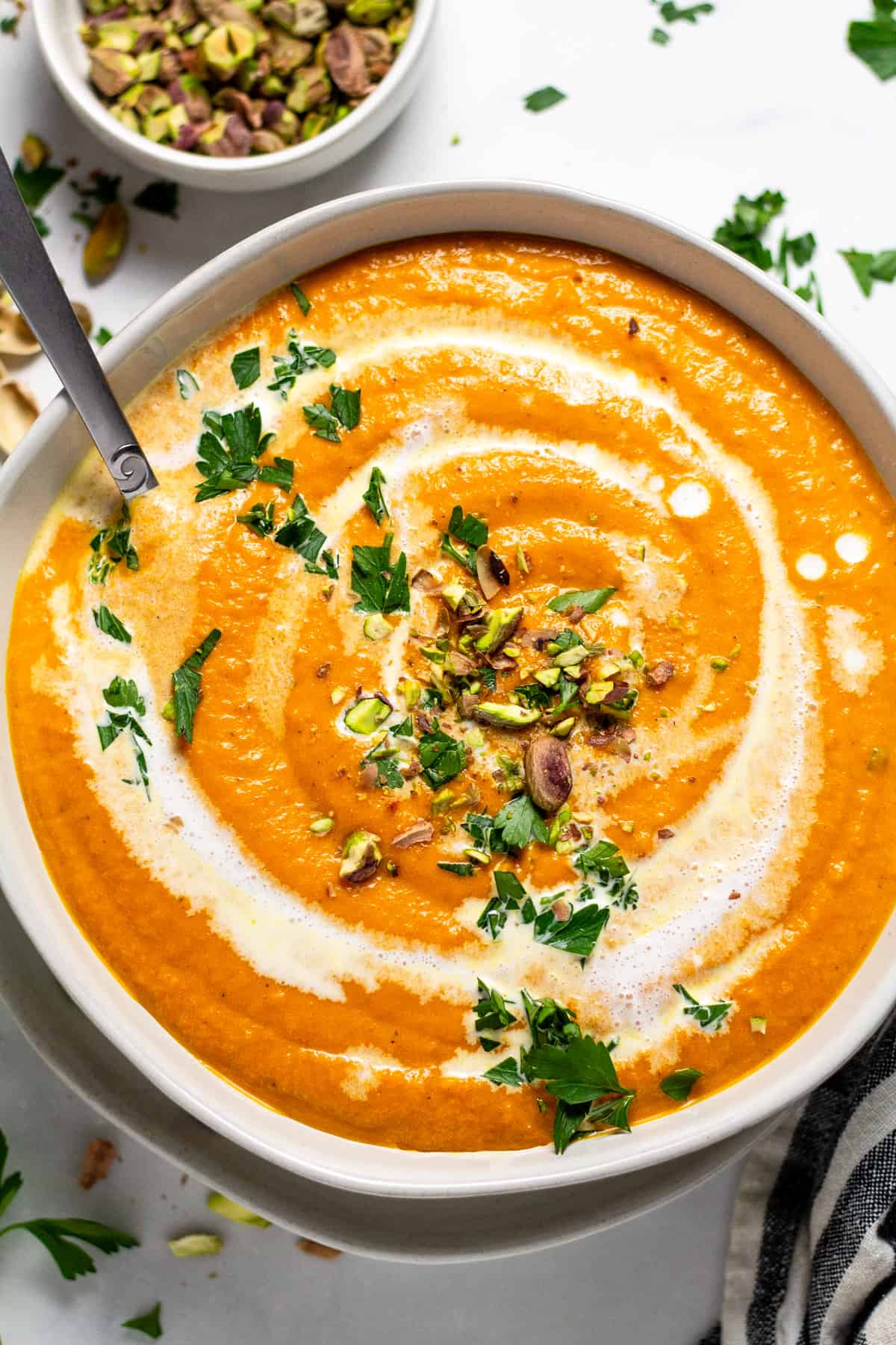 Overhead shot of a white bowl filled with creamy vegan carrot soup 