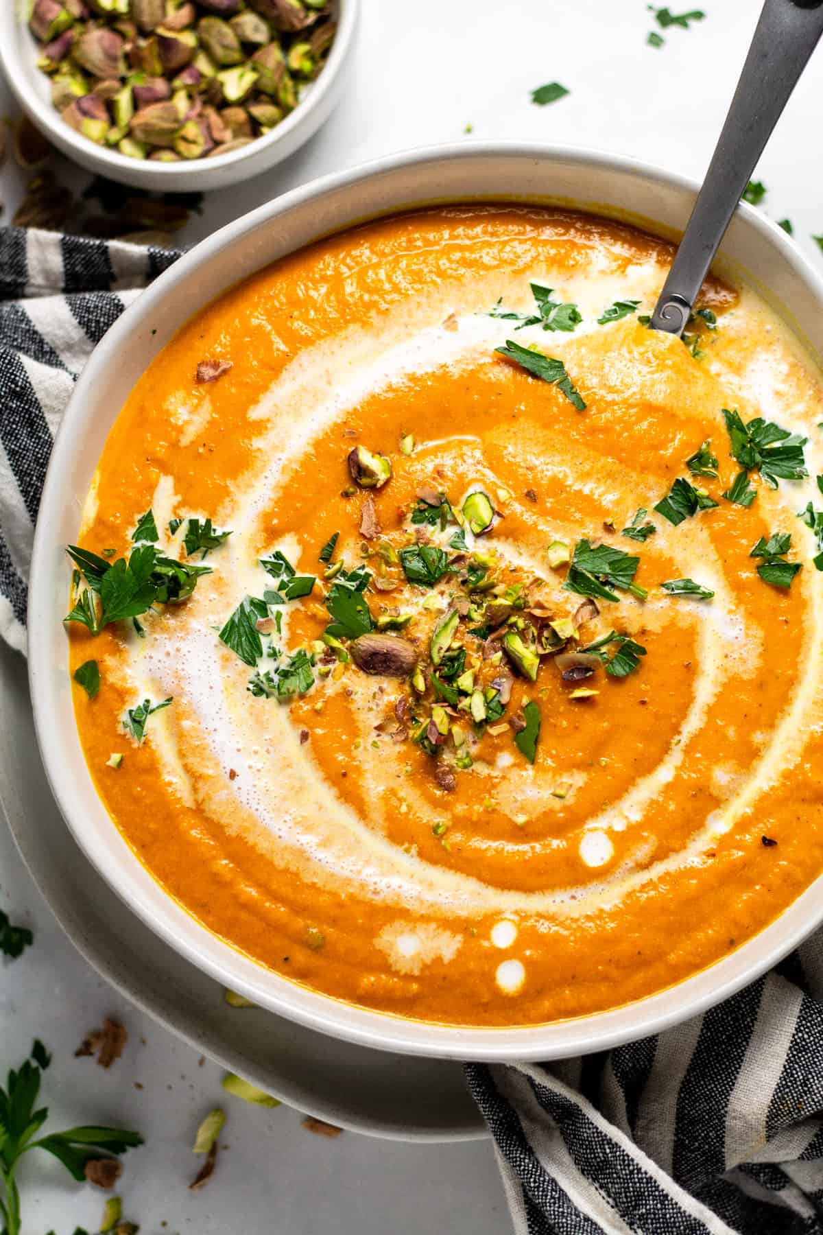 Overhead shot of a white bowl filled with creamy vegan carrot soup 