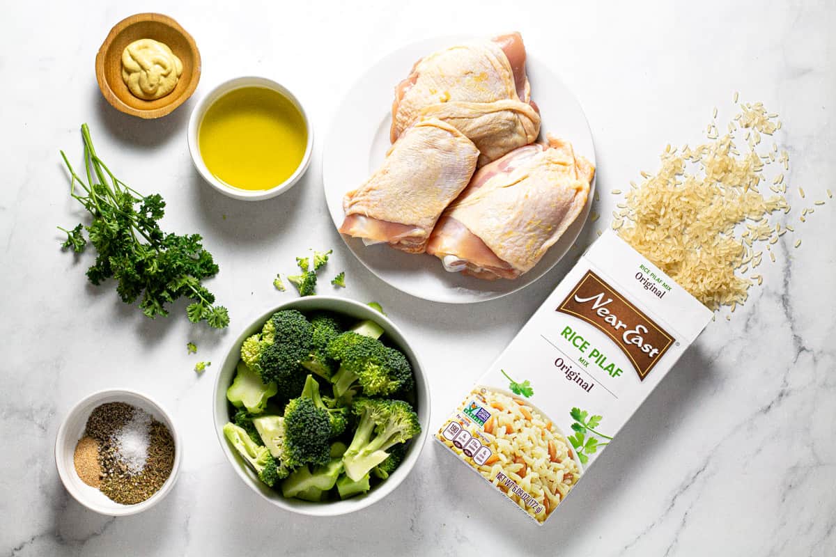 Gray marble countertop with ingredients to make roasted chicken thighs with rice and broccoli