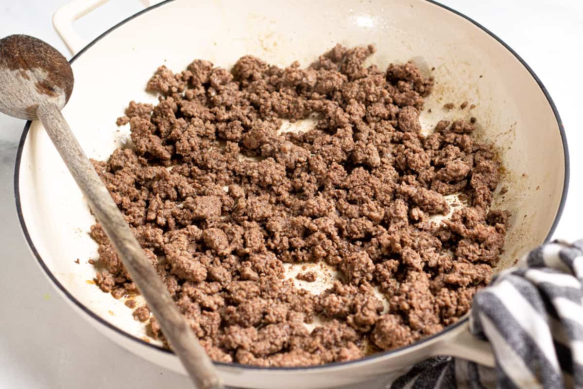 Large saute pan filled with cooked ground beef