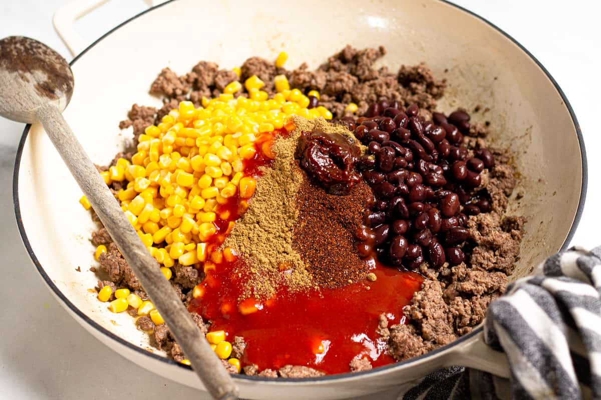 Large saute pan filled with cooked ground beef veggies and spices