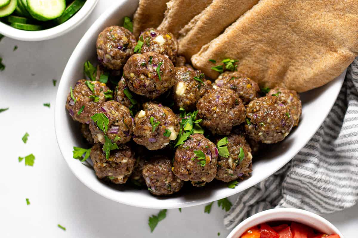 Overhead shot of a serving dish with Greek meatballs garnished with fresh parsley