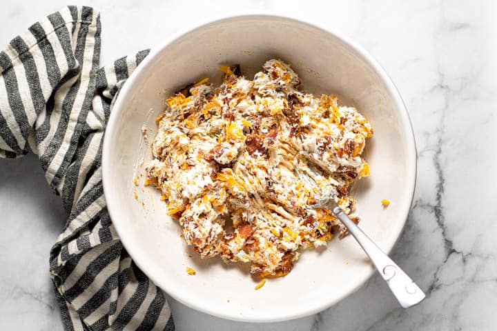 Large white bowl with ingredients to fill jalapeno poppers