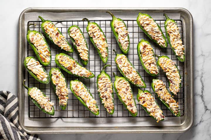 An overhead shot of a cooling rack filled with jalapeno poppers