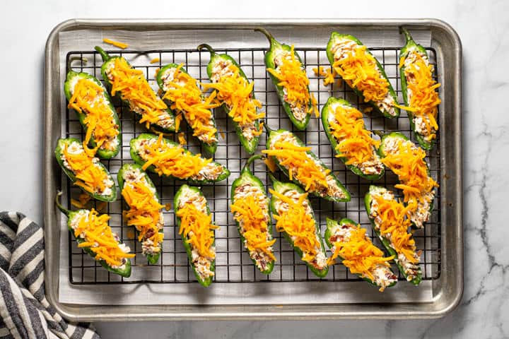 An overhead shot of a cooling rack filled with jalapeno poppers