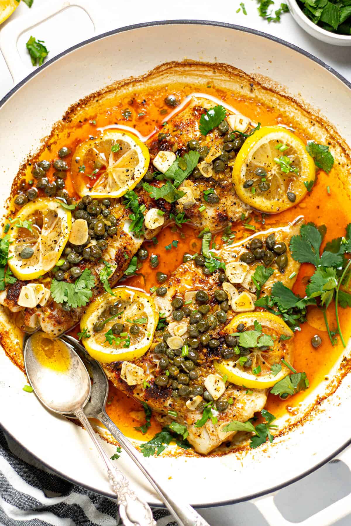 Overhead shot of a pot filled with baked Mediterranean cod garnished with fresh cilantro