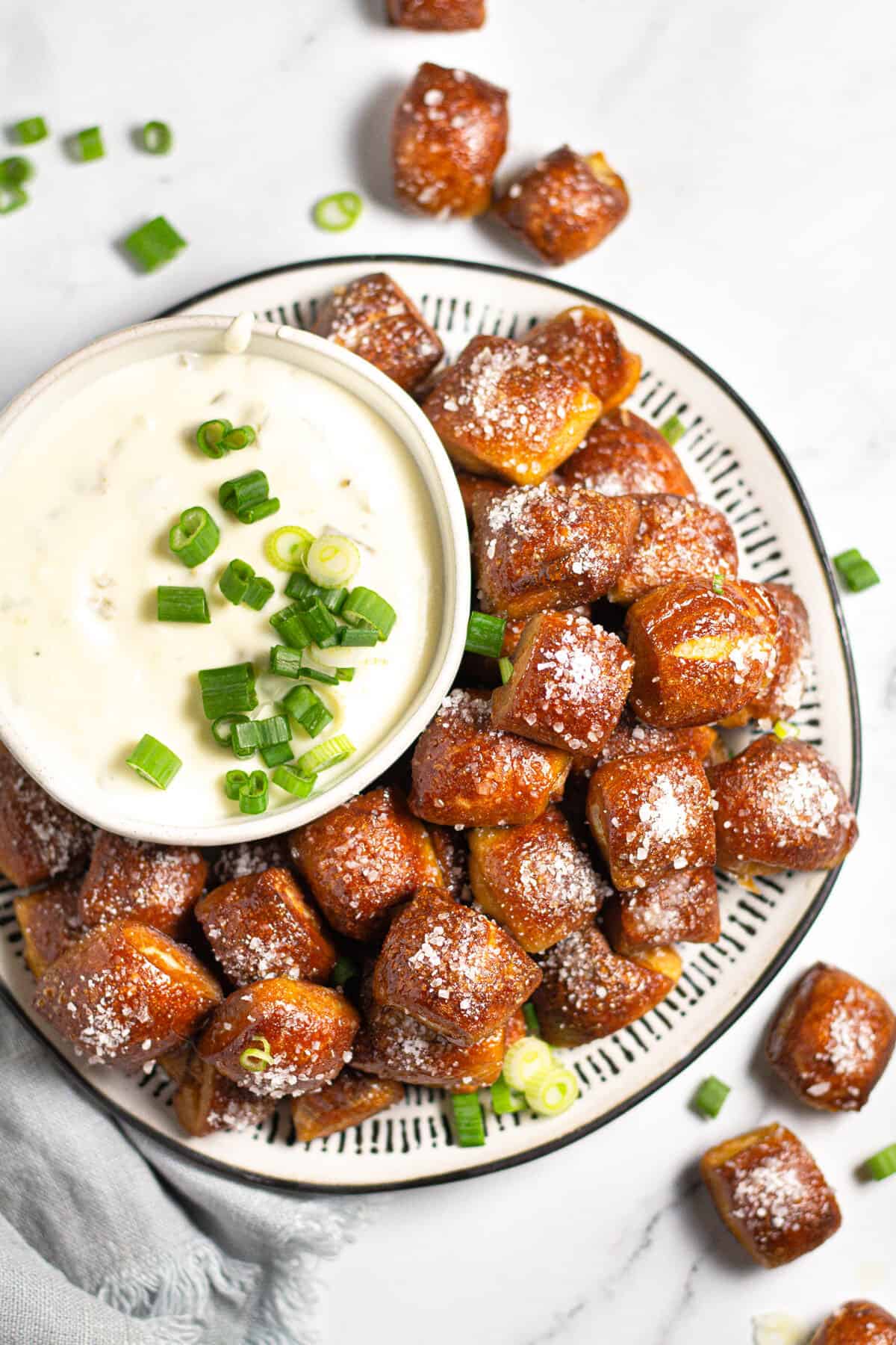 Overhead shot of a plate filled with pretzel bites and a bowl of homemade cheese dip 