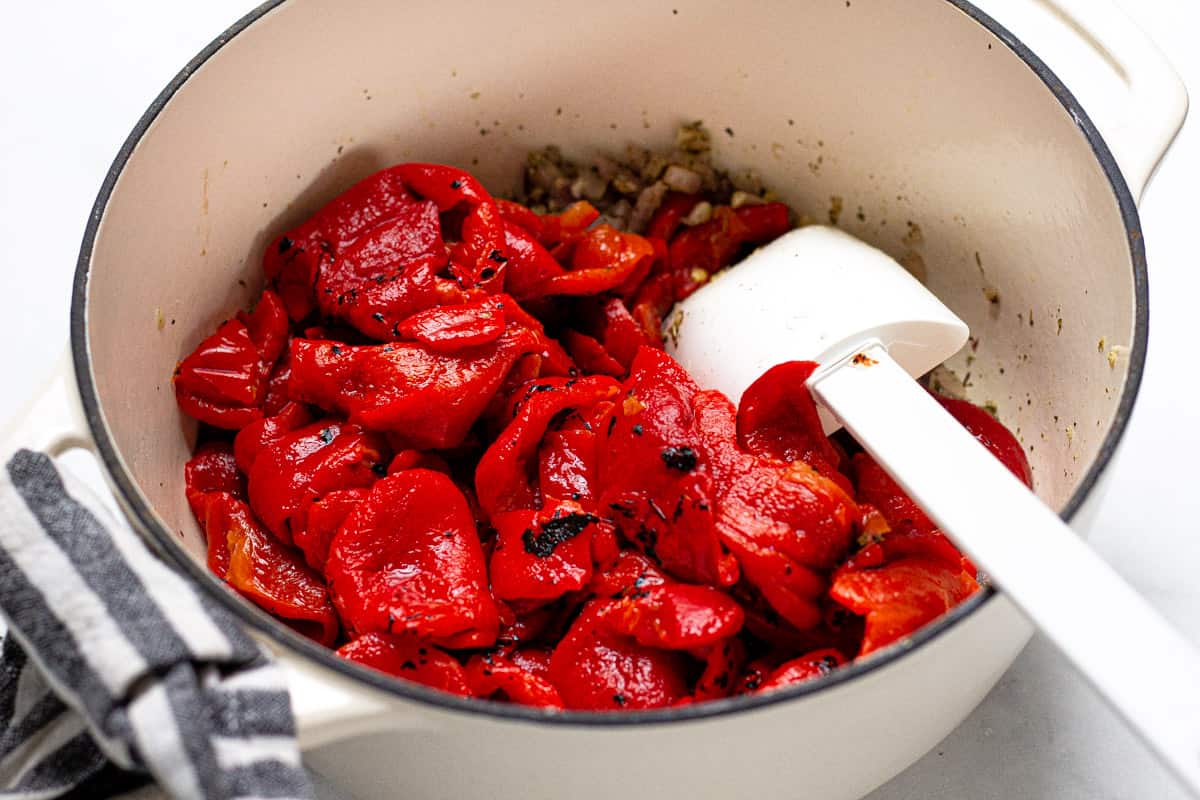 Large soup pot with ingredients to make roasted red pepper soup