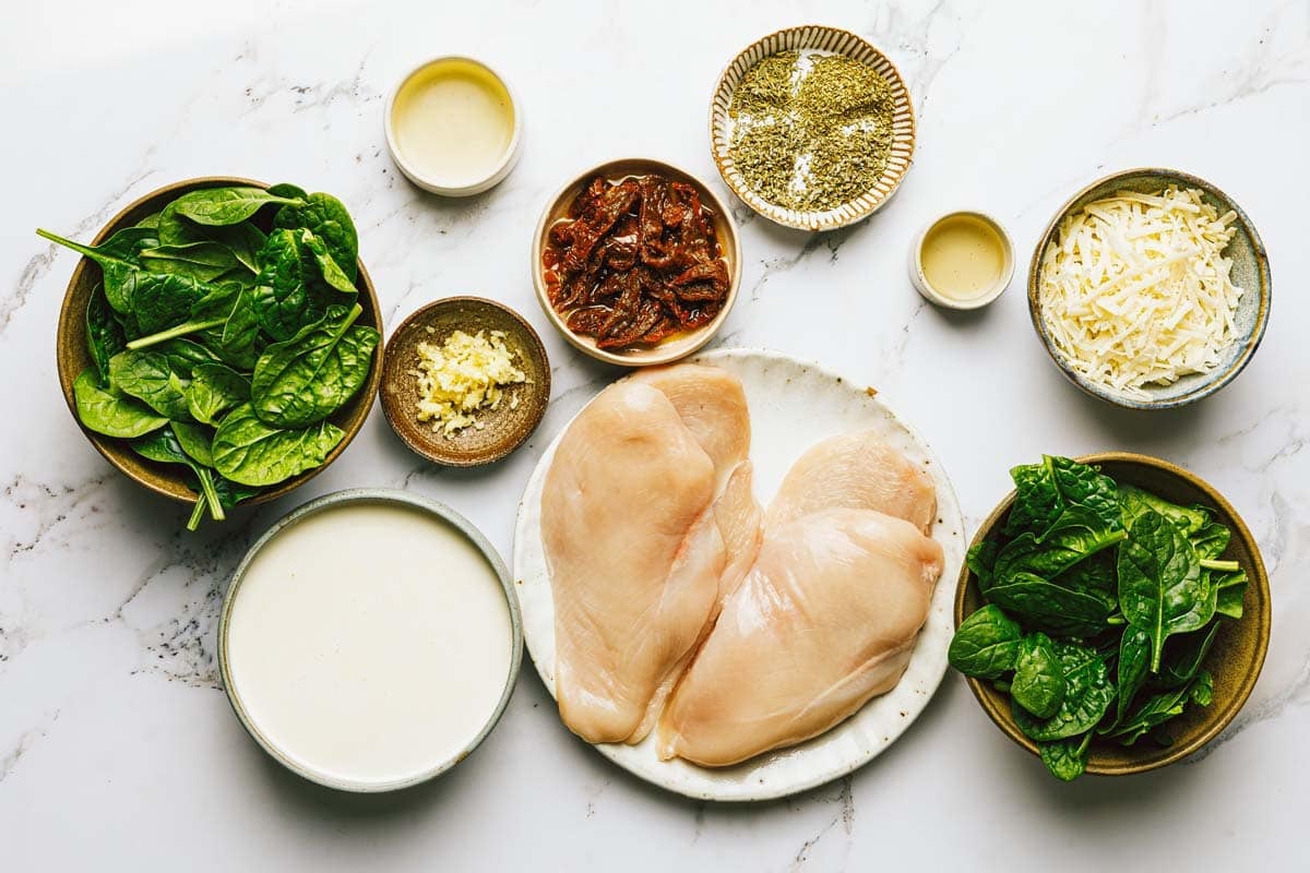 Bowls of ingredients to make creamy Tuscan chicken. 