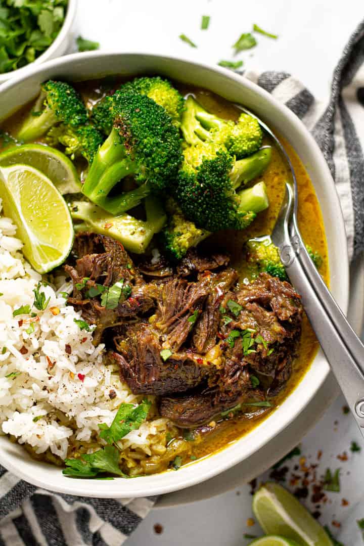 Overhead shot of a bowl of curried beef served over rice and garnished with cilantro