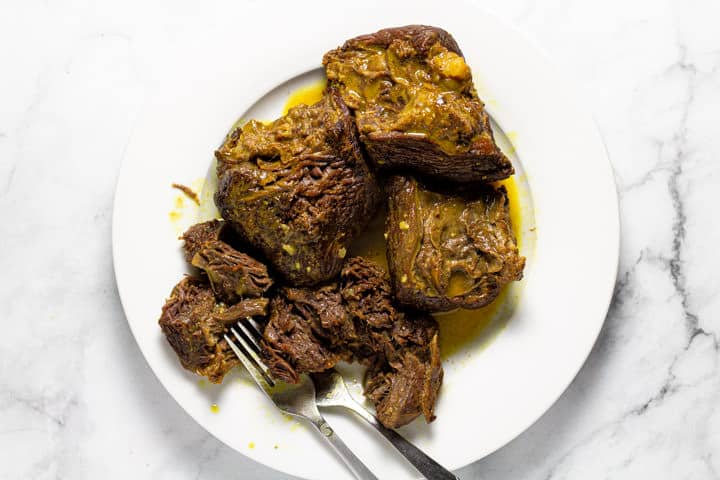 White plate with shredded curried beef on it