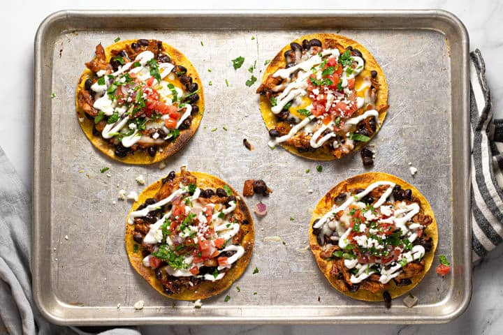 Overhead shot of a baking sheet with bbq chicken tostadas on it
