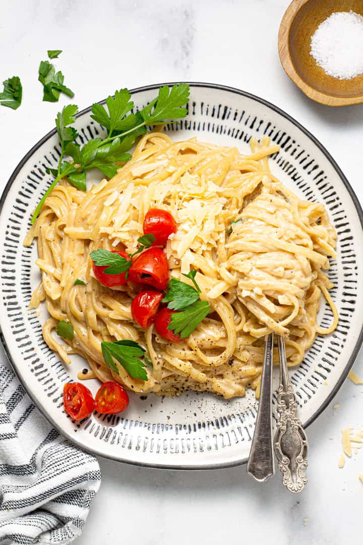 A plate filled with alfredo garnished with fresh parsley