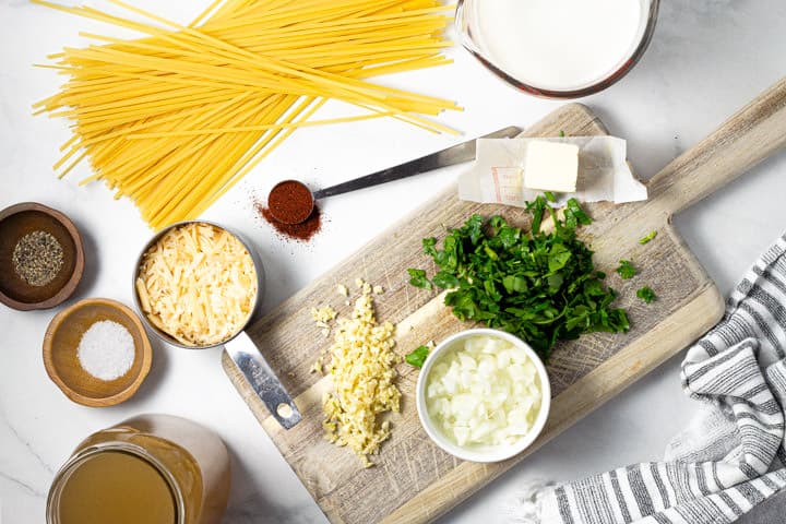 White marble counter top with ingredients used to make fettuccine alfredo in one pot