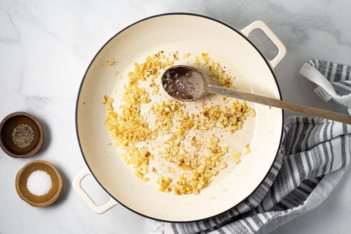 Large white pot with butter onions and garlic in it