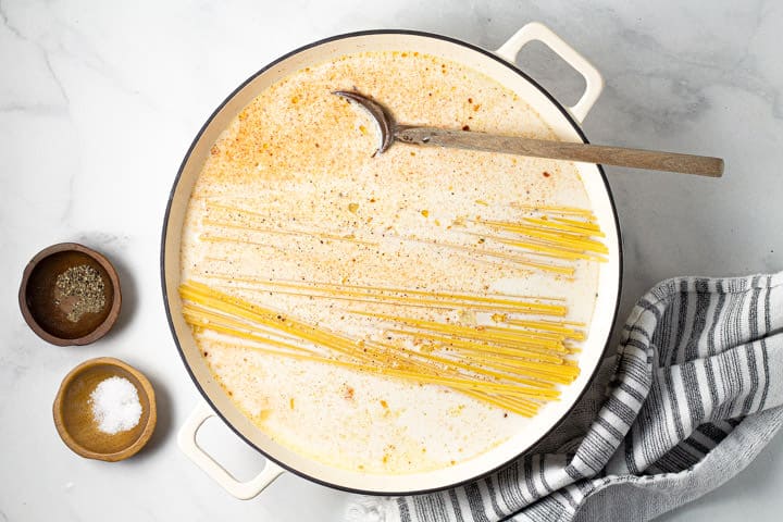 Large white pot filled with noodles half and half and broth