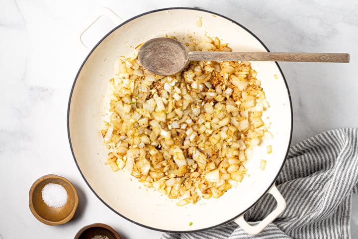 Large white pot with diced sauteed onions in it