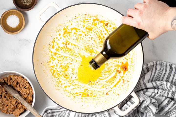 Large white pot with olive oil being poured in it