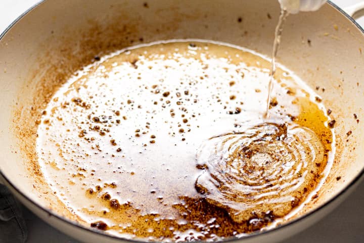Rice vinegar being poured into a large white pot