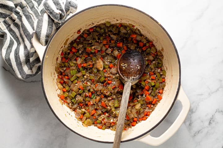 Large white pot filled with diced veggies and red wine 