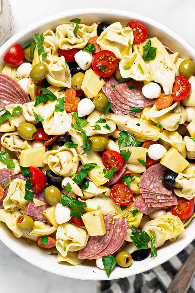 Overhead shot of a white bowl filled with pasta salad loaded with meat and veggies