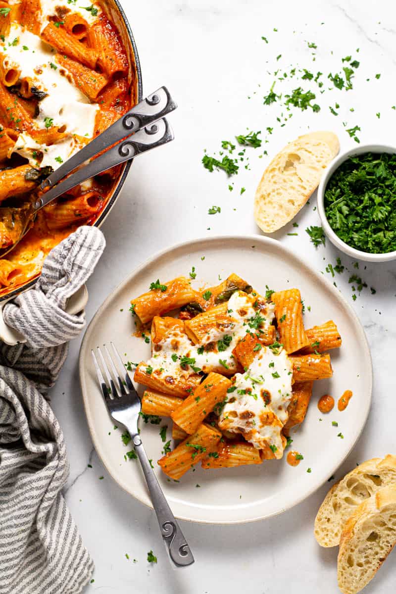 Close up shot of a plate of baked pasta garnished with fresh parsley