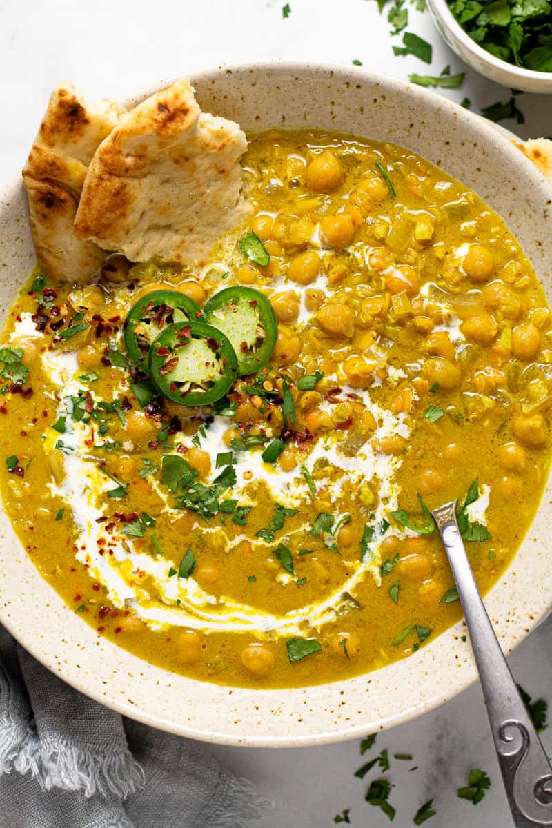 Overhead shot of a bowl of curry lentil soup garnished with coconut milk and cilantro 