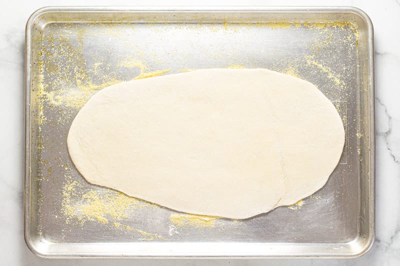 Flatbread dough on a cornmeal dusted baking sheet 