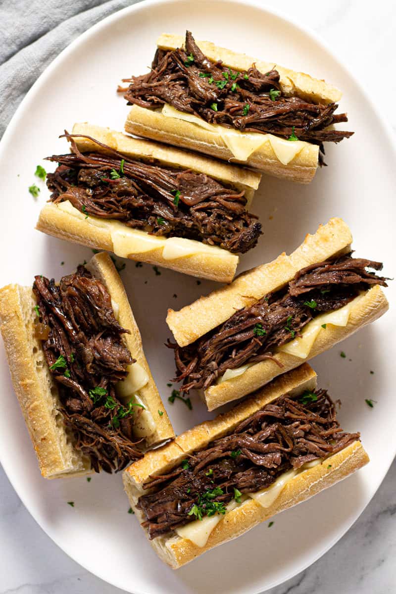 Large white platter filled with instant pot French dip sandwiches