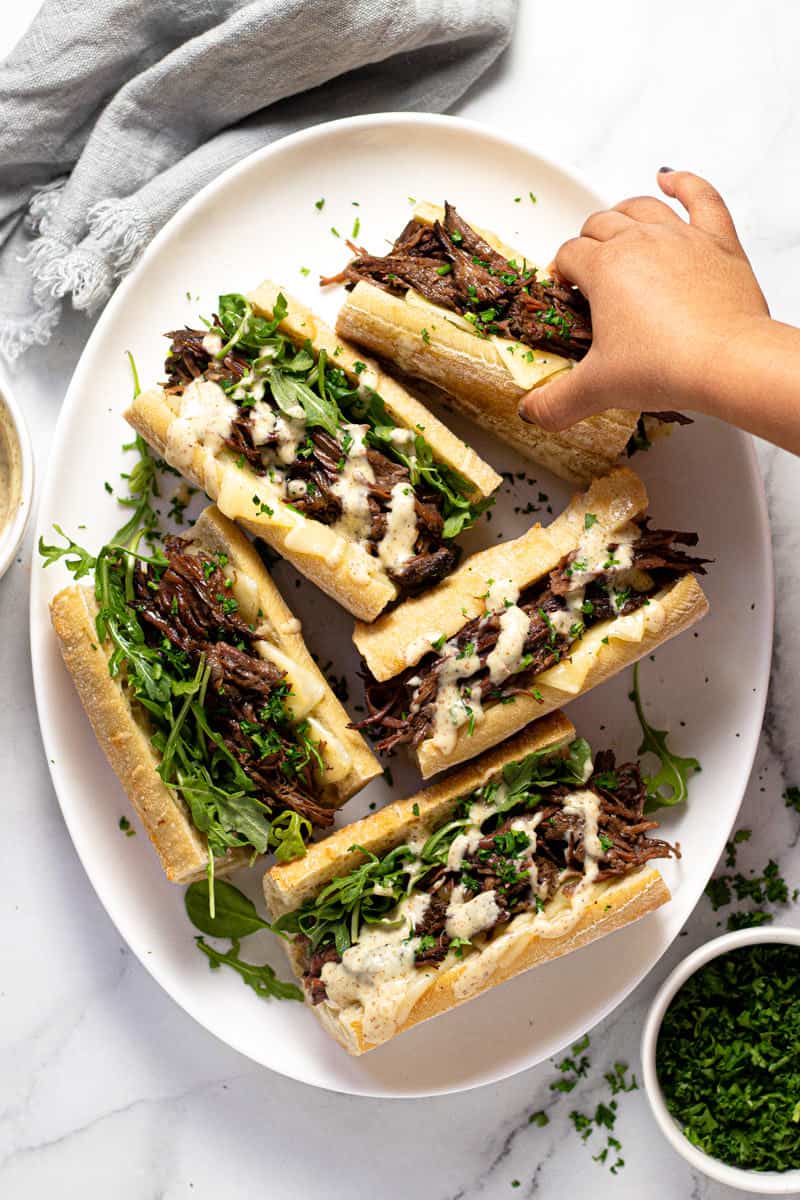 Large white platter filled with instant pot French dip sandwiches