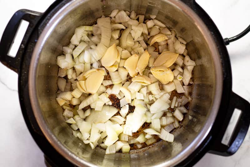 Diced onion and smashed garlic in the insert of an instant pot 
