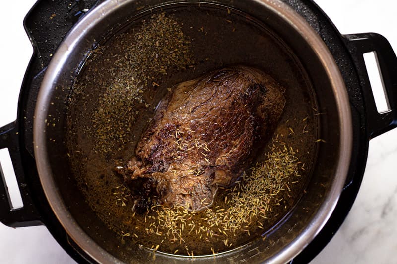 Overhead shot of an instant pot with a seared beef roast in it 