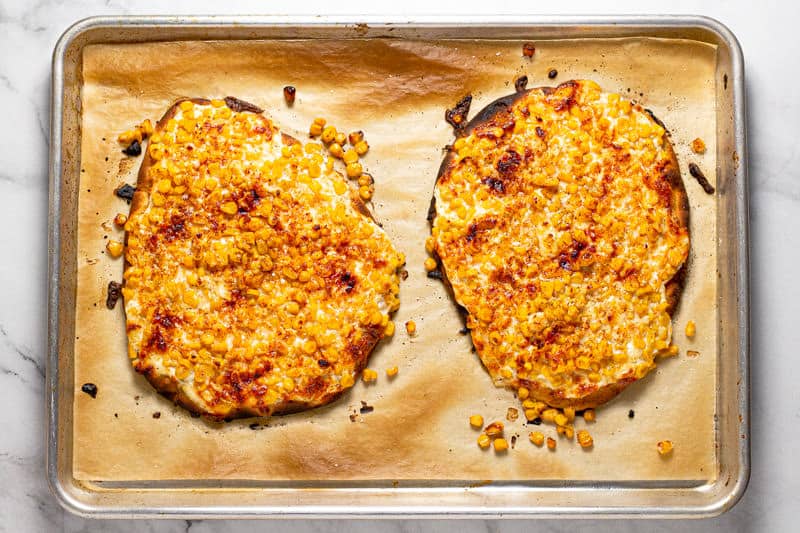 Large baking sheet with two Mexican street corn flatbreads freshly baked