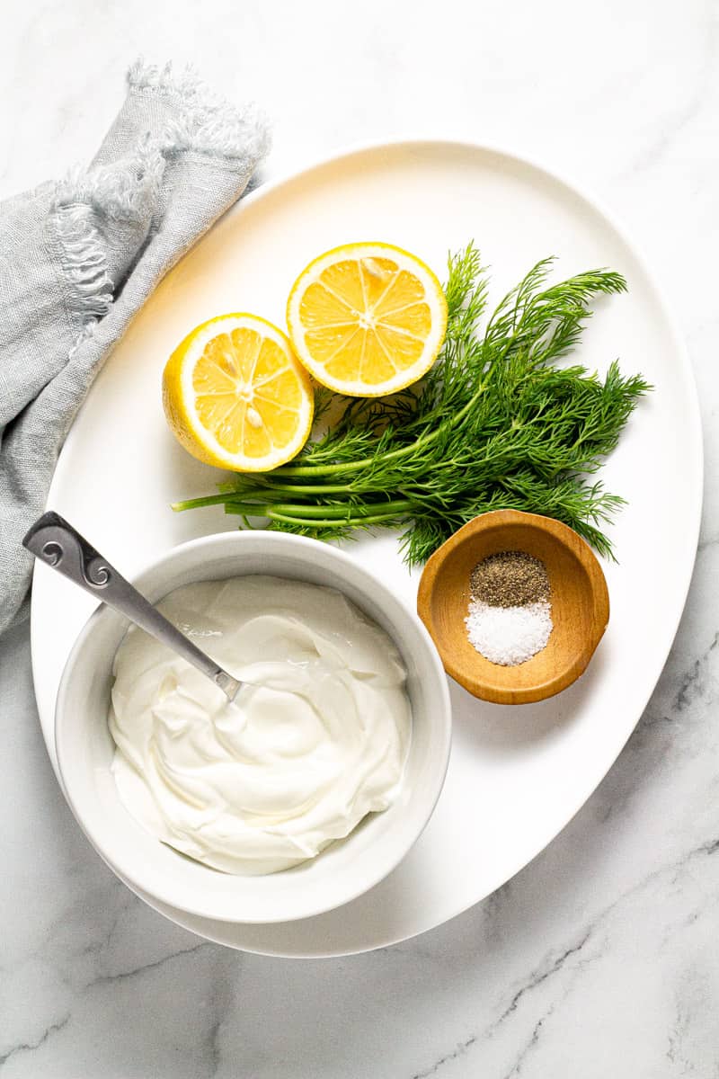 Large white platter filled with ingredients to make Greek yogurt sauce 