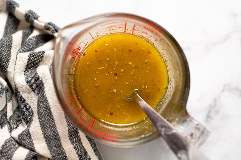 Overhead shot of a measuring cup filled with homemade vinaigrette dressing