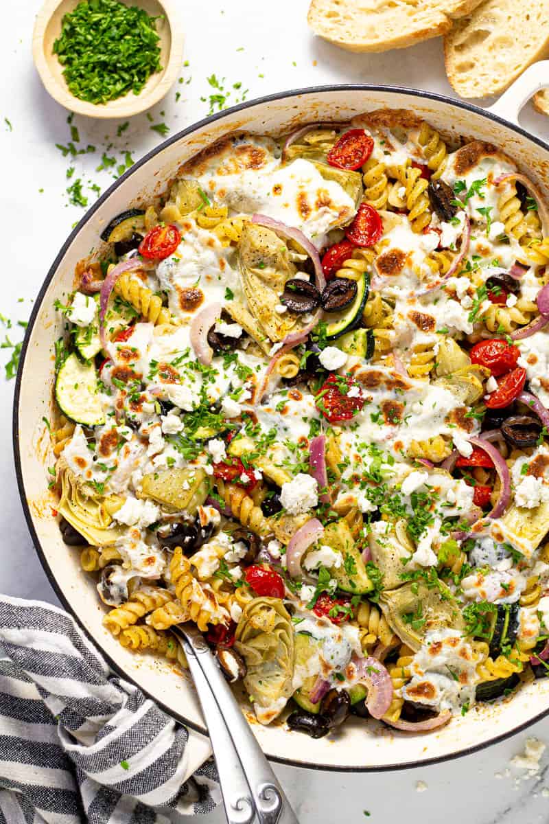 Overhead shot of a pan filled with baked Mediterranean pasta garnished with fresh parsley