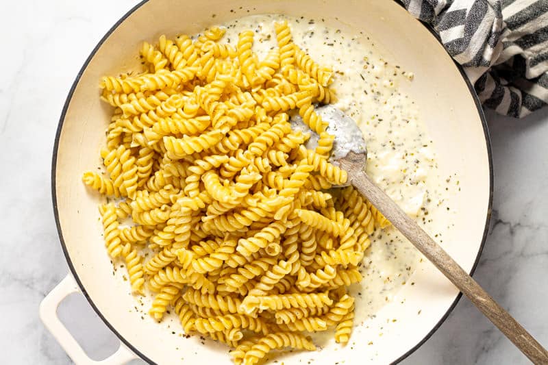 Large white pan filled with cooked noodles and feta sauce